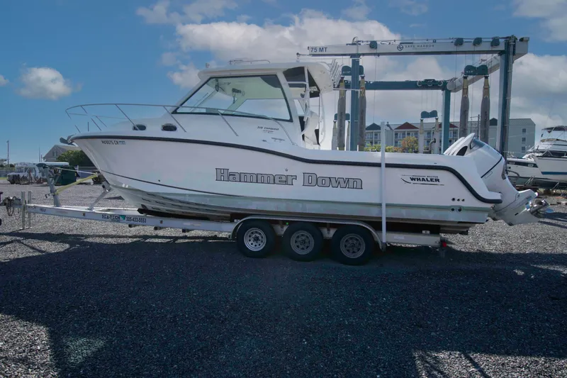 Slide: The Image of 2016 Boston Whaler 315 Conquest boat on trailer, labeled "Hammer Down," in a marina setting. - 6