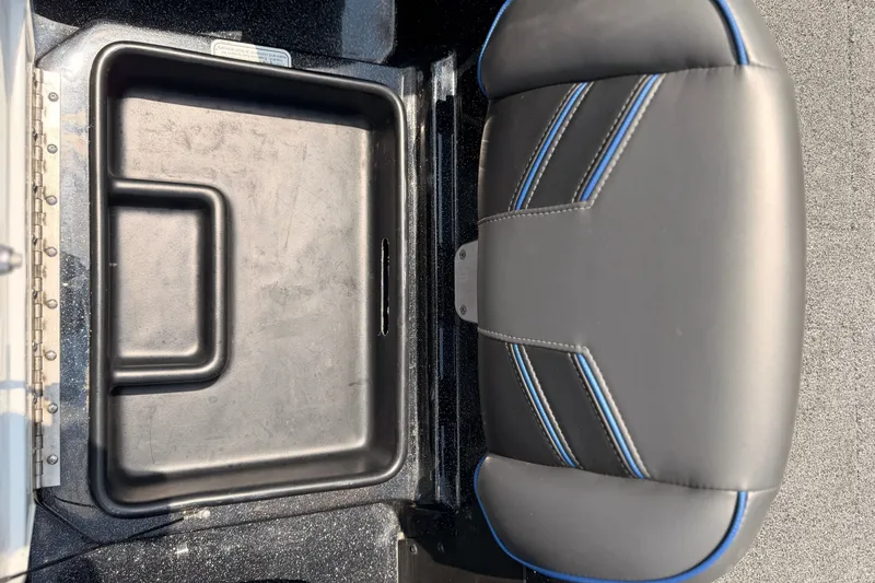 Slide: The Image of 2024 TRACKER NITRO Z21XL boat seat and storage compartment, featuring sleek black and blue design. - 20