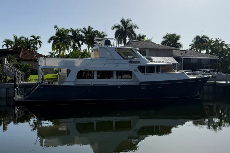 The Image of 2011 Marlow Explorer 70E yacht docked by palm trees and waterfront homes. - 0