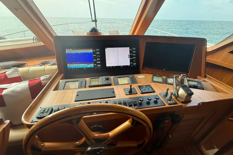 Slide: The Image of Cockpit of 2011 Marlow Explorer 70E yacht with navigation screens and wooden steering wheel. - 1