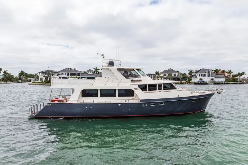 The Image of 2011 Marlow Explorer 70E yacht on water near luxury waterfront homes. - 0