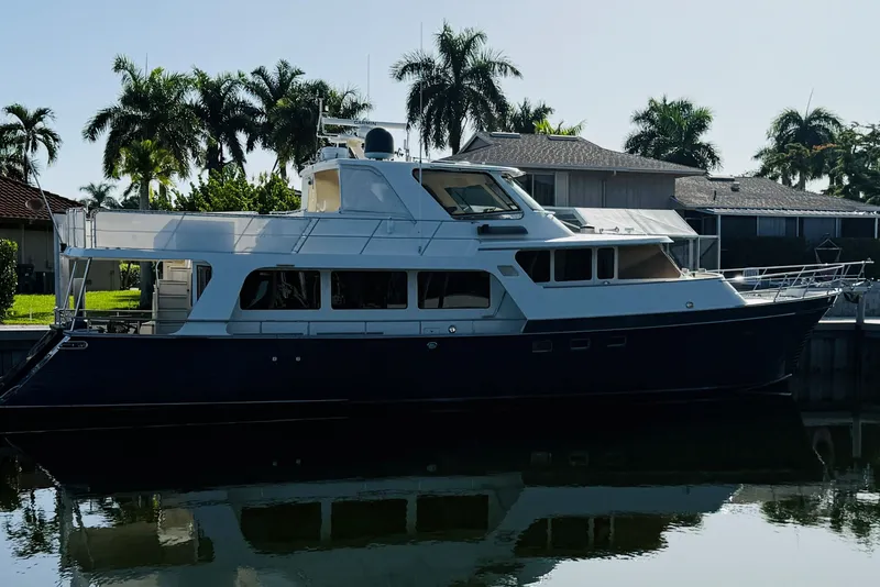 Slide: The Image of 2011 Marlow Explorer 70E yacht docked near palm trees and houses. - 9