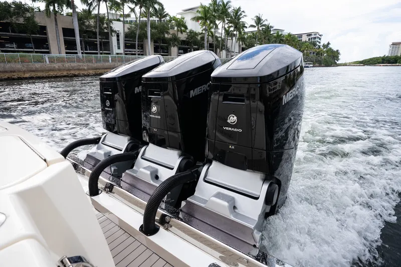 Slide: The Image of Triple Mercury Verado engines on a 2022 Scout 425 LXF boat cruising in a scenic waterway. - 31