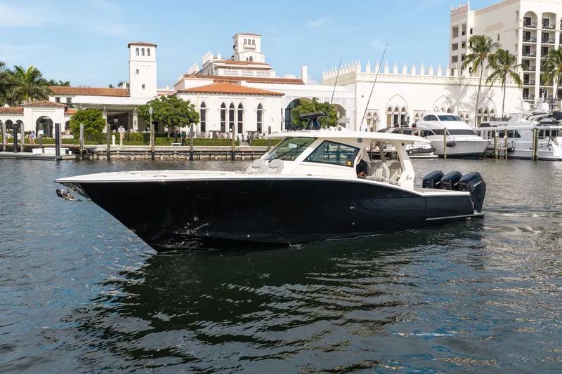 Slide: The Image of 2022 Scout 425 LXF luxury boat cruising near elegant waterfront architecture. - 7