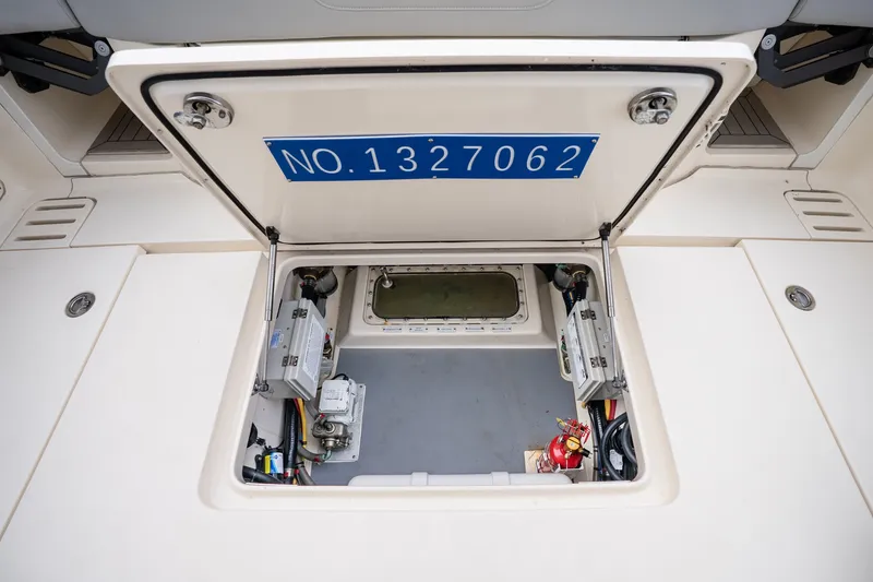 Slide: The Image of Open hatch of 2022 Scout 425 LXF boat showing interior equipment and wiring. - 27