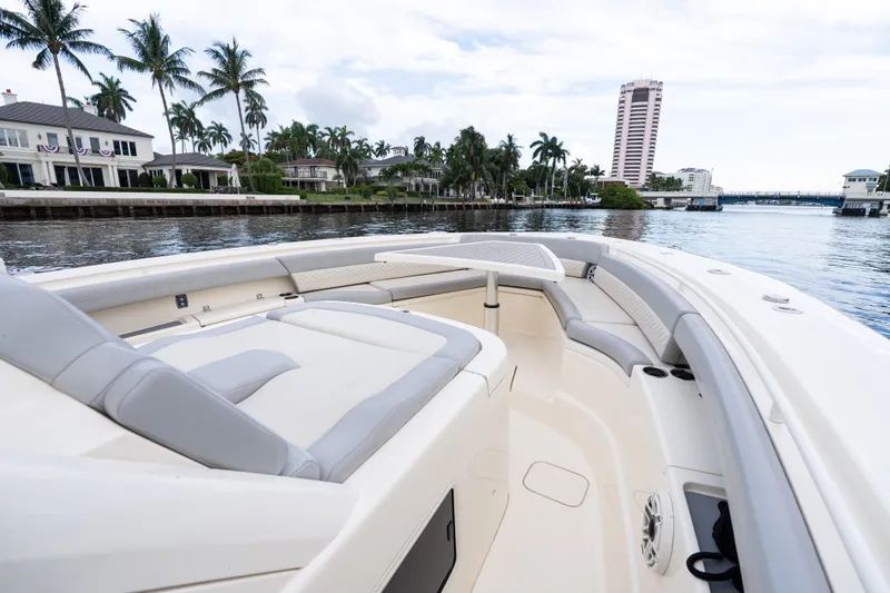 Slide: The Image of 2022 Scout 425 LXF boat cruising near waterfront homes and palm trees. - 10