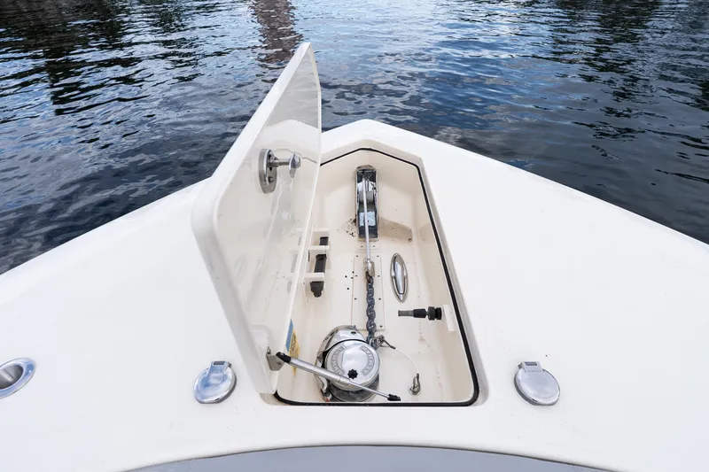 Slide: The Image of Open anchor compartment on 2022 Scout 425 LXF boat, showing anchor chain and winch. - 8