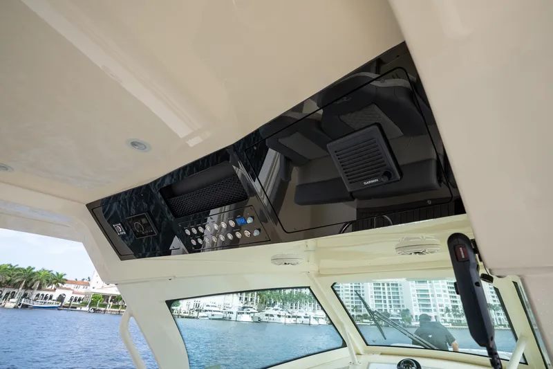 Slide: The Image of Interior view of 2022 Scout 425 LXF boat's control panel with waterfront background. - 22