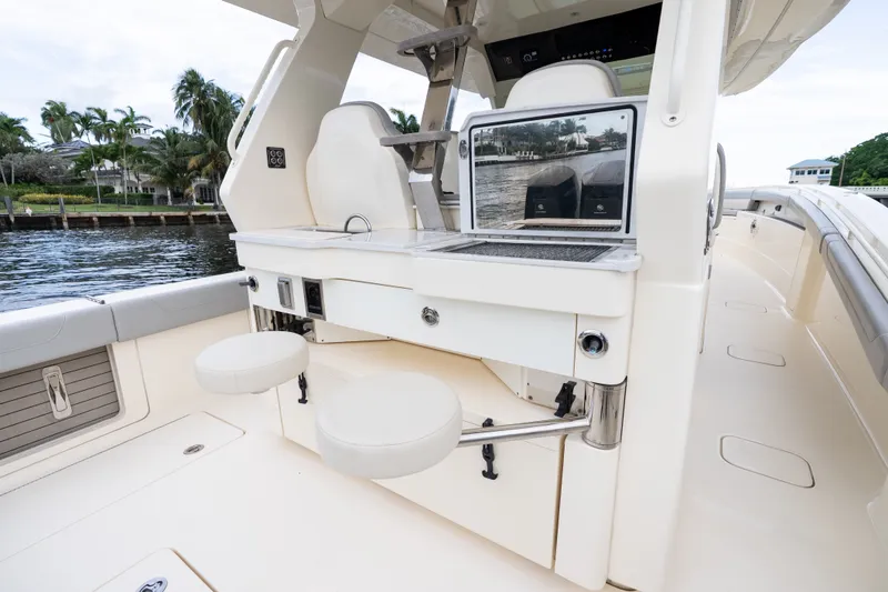 Slide: The Image of 2022 Scout 425 LXF boat interior with seating and helm station, dockside view. - 15