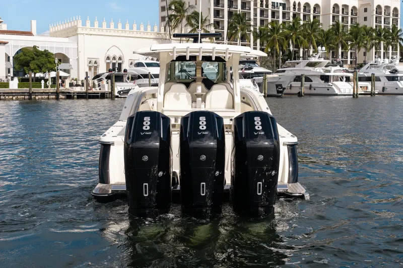 Slide: The Image of 2022 Scout 425 LXF boat with four powerful outboard engines docked at a marina. - 5