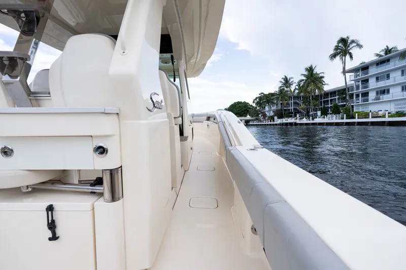 Slide: The Image of 2022 Scout 425 LXF boat docked by waterfront homes and palm trees. - 14