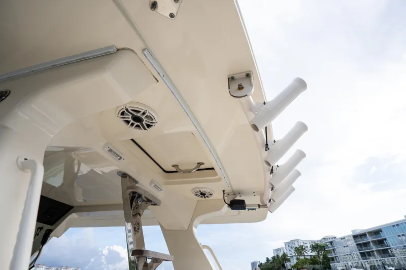 Slide: The Image of 2022 Scout 425 LXF boat roof with rod holders and speakers, cityscape in background. - 30