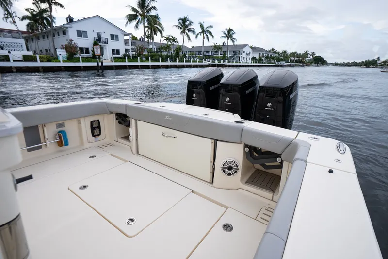 Slide: The Image of 2022 Scout 425 LXF boat with triple Mercury engines, docked near waterfront homes. - 17