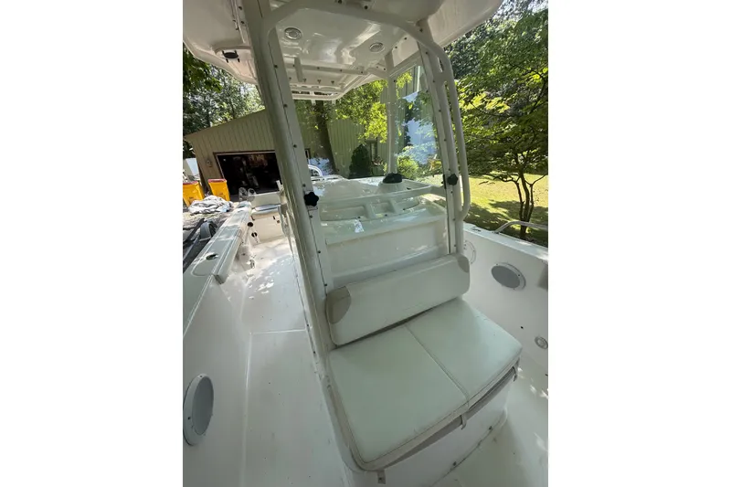 Slide: The Image of 2011 Everglades 230 Center Console boat interior with seating and console, surrounded by greenery. - 19