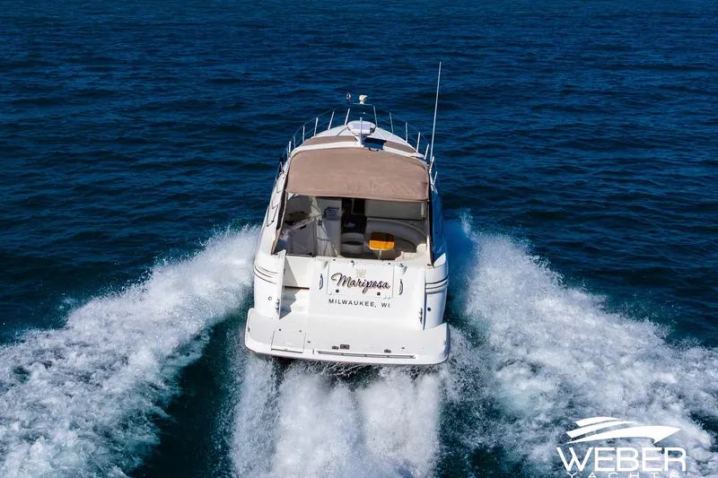 Slide: The Image of 2001 Cruisers Yachts 3870 Express cruising on open water, rear view. - 8