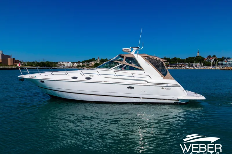 Slide: The Image of 2001 Cruisers Yachts 3870 Express on water, clear sky, coastal background. - 11