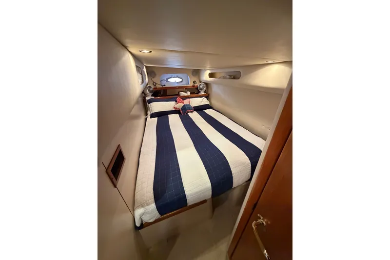 Slide: The Image of Cozy cabin interior of 2001 Cruisers Yachts 3870 Express with striped bedding. - 25