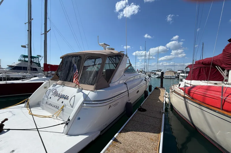 Slide: The Image of 2001 Cruisers Yachts 3870 Express docked at marina under clear blue sky. - 2