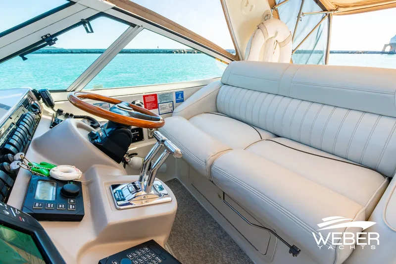 Slide: The Image of Luxurious helm of 2001 Cruisers Yachts 3870 Express with leather seating and wooden steering wheel. - 28