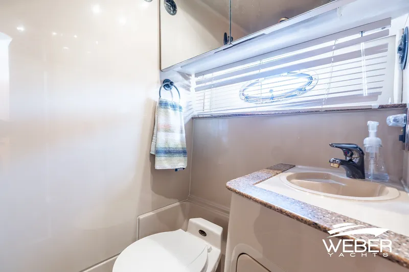 Slide: The Image of 2001 Cruisers Yachts 3870 Express bathroom with sink, toilet, and window blinds. - 37