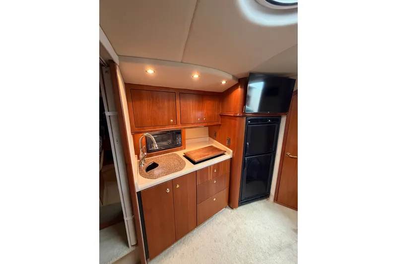 Slide: The Image of 2001 Cruisers Yachts 3870 Express interior kitchen with wood cabinetry and modern appliances. - 22