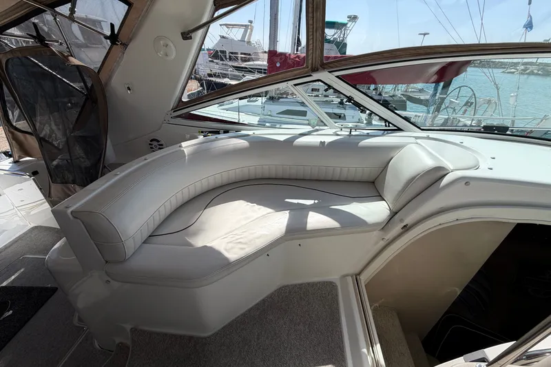 Slide: The Image of 2001 Cruisers Yachts 3870 Express interior with curved seating and marina view. - 13
