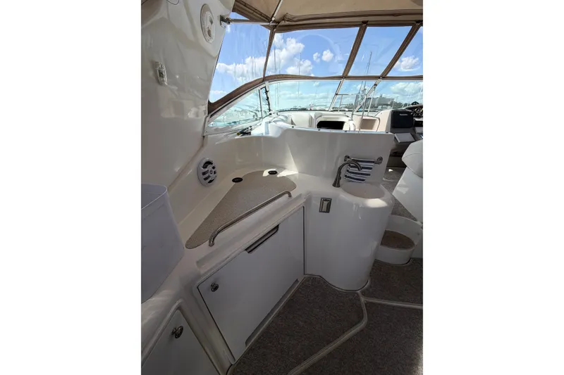 Slide: The Image of 2001 Cruisers Yachts 3870 Express cockpit with sink and storage, featuring panoramic windows. - 8