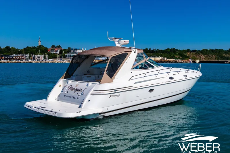 Slide: The Image of 2001 Cruisers Yachts 3870 Express on water, Milwaukee backdrop, clear blue sky. - 13