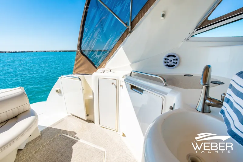 Slide: The Image of 2001 Cruisers Yachts 3870 Express interior with sink, seating, and ocean view. - 19