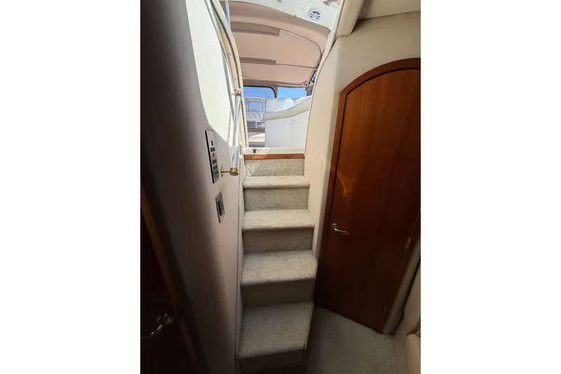 Slide: The Image of Staircase leading to deck on 2001 Cruisers Yachts 3870 Express, featuring wooden door and carpeted steps. - 18