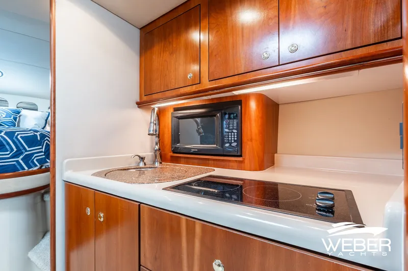 Slide: The Image of 2001 Cruisers Yachts 3870 Express kitchen with stove, microwave, and sink. - 32
