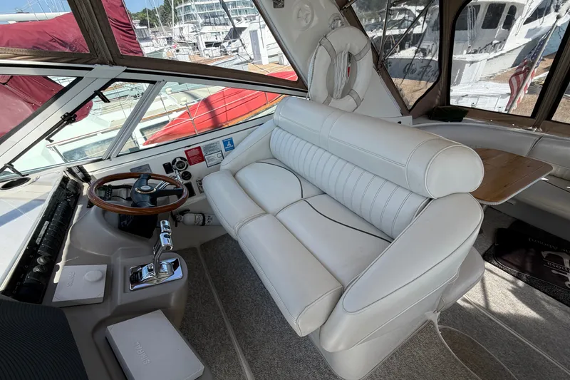 Slide: The Image of 2001 Cruisers Yachts 3870 Express helm with white leather seating and wooden steering wheel. - 14