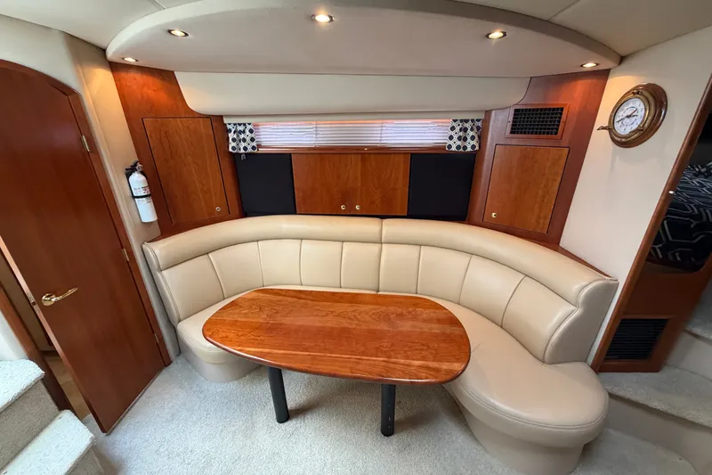 Slide: The Image of Luxurious interior of 2001 Cruisers Yachts 3870 Express with curved seating and wooden table. - 19