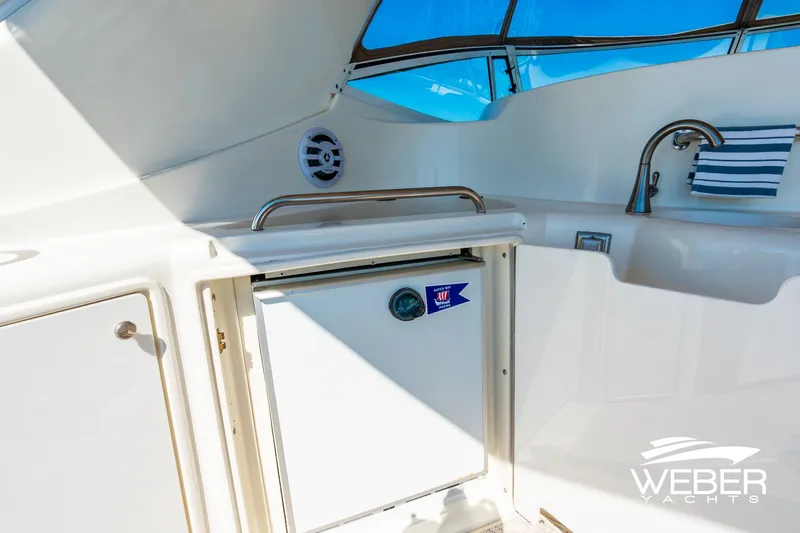 Slide: The Image of 2001 Cruisers Yachts 3870 Express cockpit with sink, mini-fridge, and storage cabinets. - 20