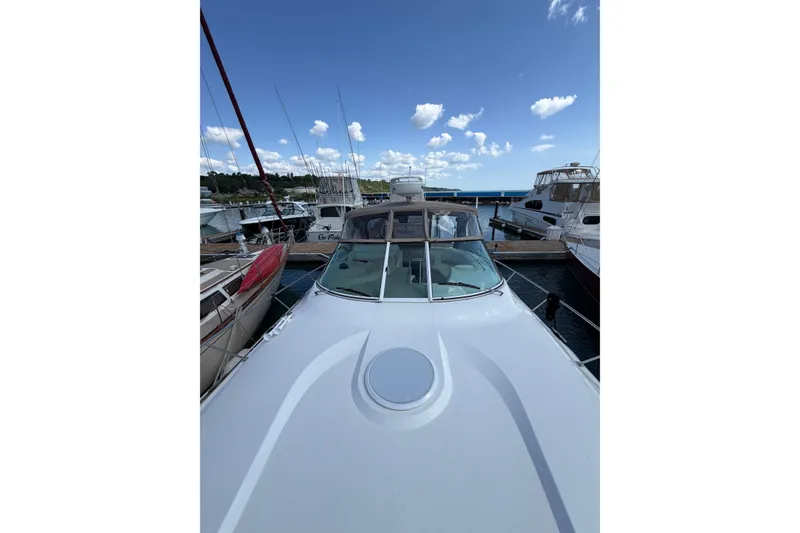 Slide: The Image of 2001 Cruisers Yachts 3870 Express docked at marina under blue sky. - 3