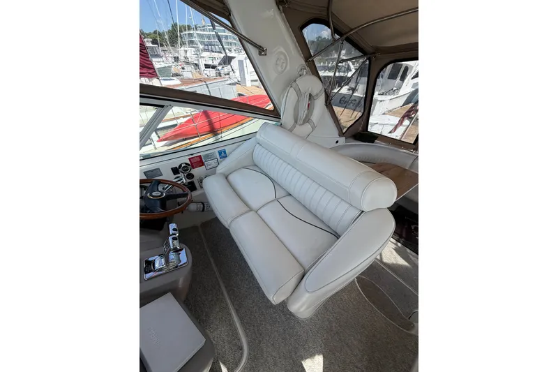Slide: The Image of 2001 Cruisers Yachts 3870 Express cockpit with white seating and helm controls. - 16