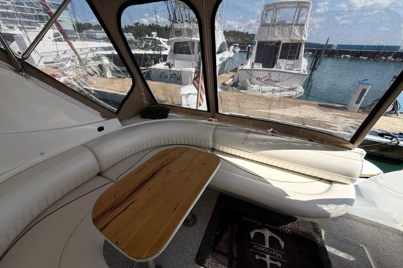 Slide: The Image of Interior view of 2001 Cruisers Yachts 3870 Express with seating and wooden table. - 10