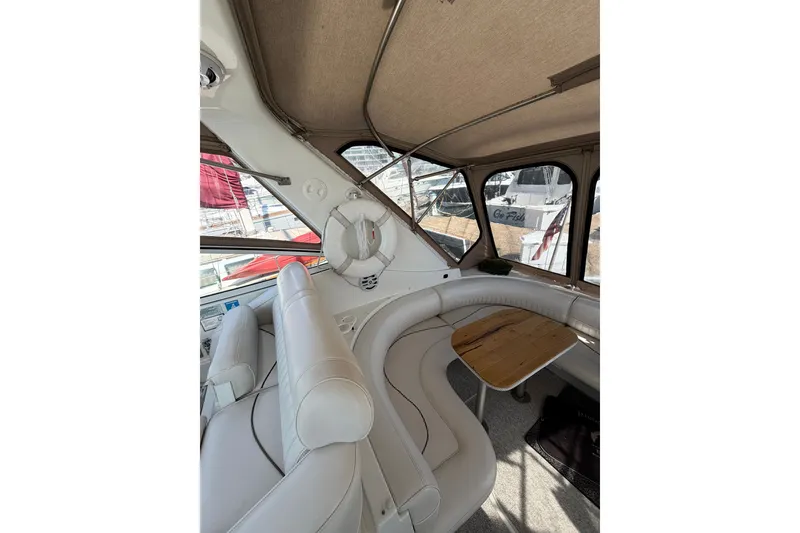 Slide: The Image of Interior of 2001 Cruisers Yachts 3870 Express with white seating and wooden table. - 12