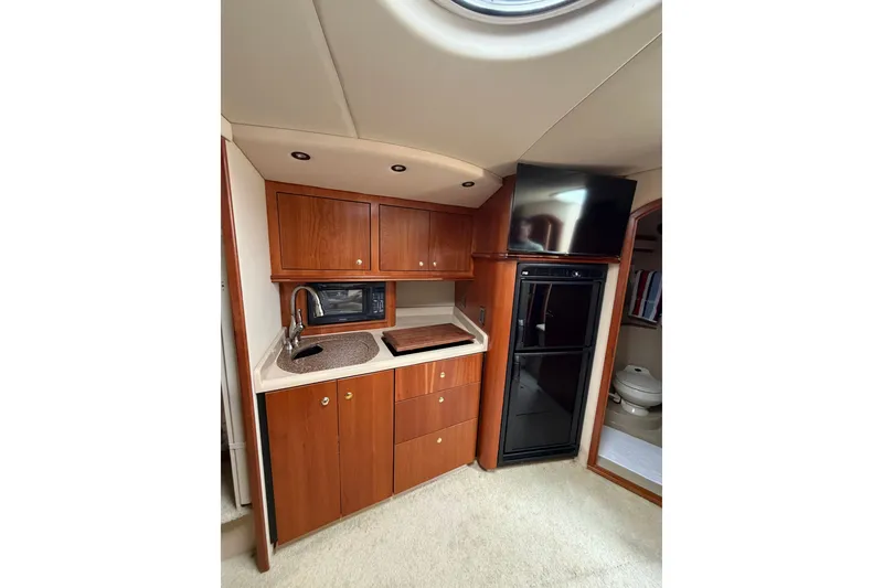 Slide: The Image of 2001 Cruisers Yachts 3870 Express interior kitchen with wood cabinets, sink, and appliances. - 20