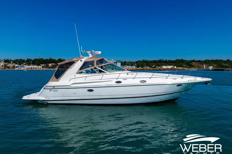 Slide: The Image of 2001 Cruisers Yachts 3870 Express on calm water, clear sky, side view. - 12