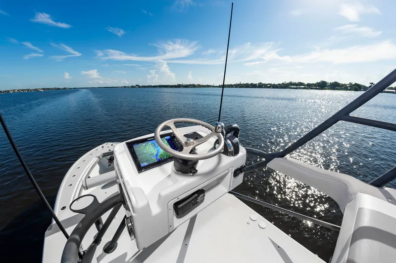 Slide: The Image of The image shows the helm of a 2015 Yellowfin 39 Offshore boat on calm water. - 25