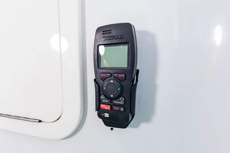 Slide: The Image of A Simrad radio is mounted on the white wall of a boat. - 22