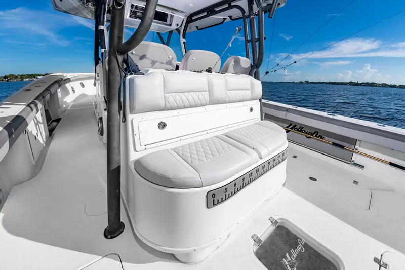 Slide: The Image of The image shows the cockpit of a 2015 Yellowfin 39 Offshore boat with white upholstery and a clear blue sky. - 33
