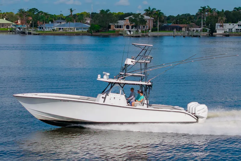 Slide: The Image of A 2015 Yellowfin 39 Offshore speeds across calm waters, surrounded by houses and palm trees. - 41