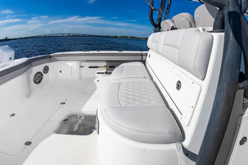 Slide: The Image of The image shows the spacious cockpit of a 2015 Yellowfin 39 Offshore boat with white upholstery. - 32