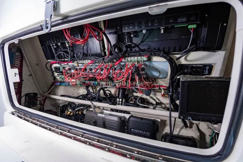 Slide: The Image of An open electronics compartment reveals complex wiring and equipment inside a boat. - 19
