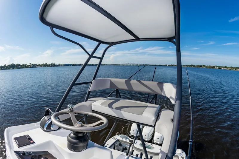 Slide: The Image of The image shows the helm of a 2015 Yellowfin 39 Offshore boat on calm waters. - 24