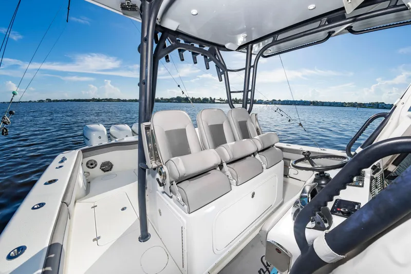 Slide: The Image of The image shows the cockpit of a 2015 Yellowfin 39 Offshore boat with gray seats and fishing rods. - 15