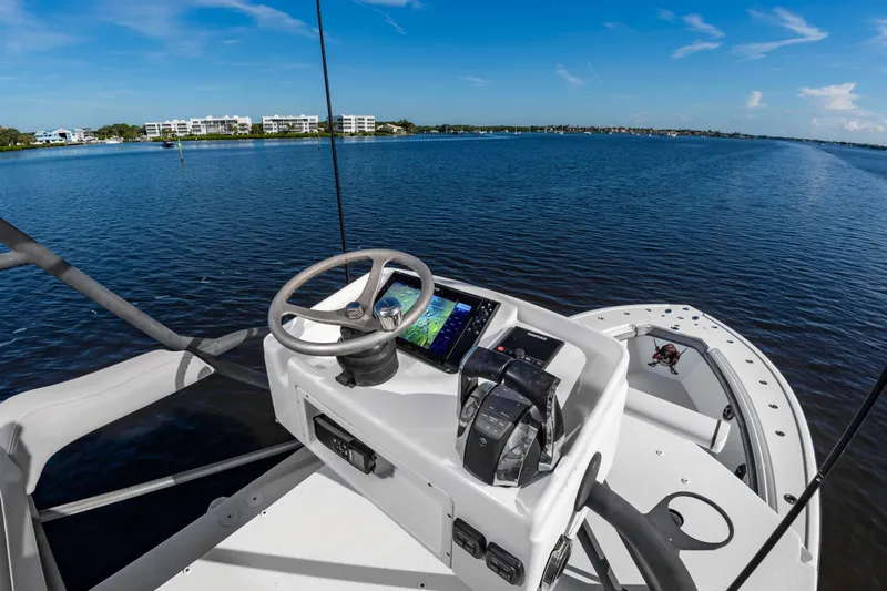 Slide: The Image of The image shows the helm of a 2015 Yellowfin 39 Offshore boat on calm waters. - 26