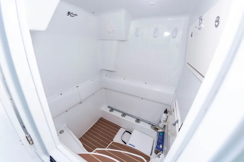 Slide: The Image of Interior of a 2015 Yellowfin 39 Offshore with a clean white design and wood flooring. - 17
